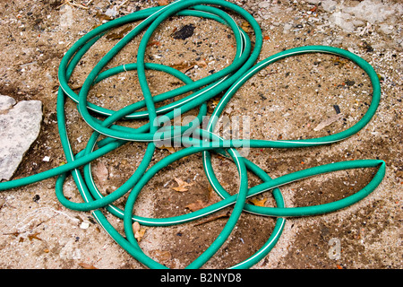 Grünes Wasserschlauch auf dem Boden liegend Stockfoto