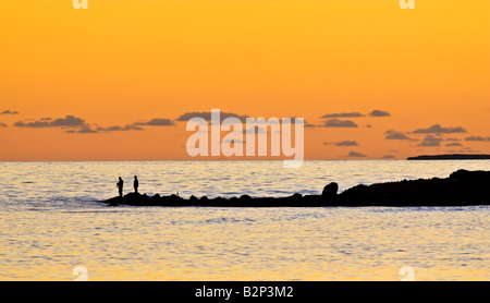 Silhouette der beiden Fischer Angeln im Meer bei Sonnenuntergang am Woodman Point, Perth, Western Australia Stockfoto