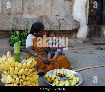 Eine indische Frau und Kind verkaufen Bananen in Hampi, Indien. Stockfoto