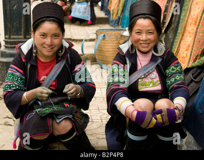 Zwei schwarze Hmong Stamm-Frauen tragen traditionelle Kostüm lächelnd auf den Betrachter in Sapa Vietnam Stockfoto