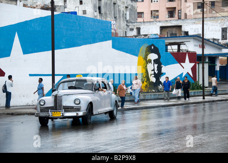 Vintage Taxi Taxi vorbei ein Wandbild von Ernesto Che Guevara während der Zeit des Embargos in Centro Habana Cuba Kuba Stockfoto