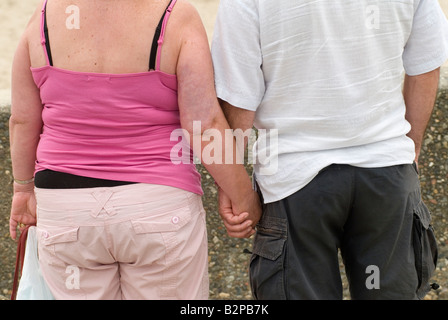 UK gewöhnliches englisches übergewichtiges Paar mittleren Alters hält Hände an Urlaub Wales Rückansicht 2008 2000er Jahre HOMER SYKES Stockfoto