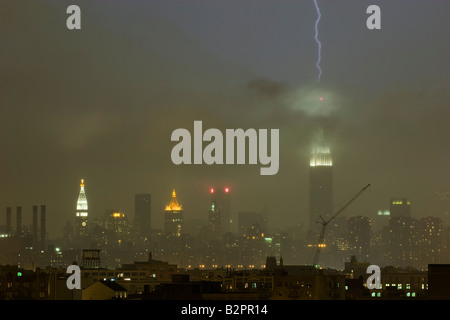 Blitz schlägt das Empire State Building bei Starkregen Sturm. Brooklyn steht im Vordergrund. Stockfoto