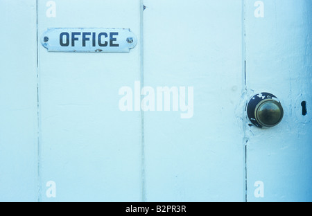 Solide weite beplankt Holztür mit altmodischen schwarzen und weißen Schild besagt Büro mit Messing Türknopf weiß lackiert Stockfoto