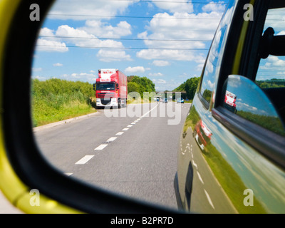 Blick auf der Straße hinter - Rückansicht einer englischen zweispurigen Straße durch eine Auto-Außenspiegel UK Stockfoto