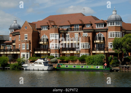 Narrowboat und Motor Cruiser vertäut am Fluss Themse vor riverside Apartments in Eton, Berkshire, England Stockfoto