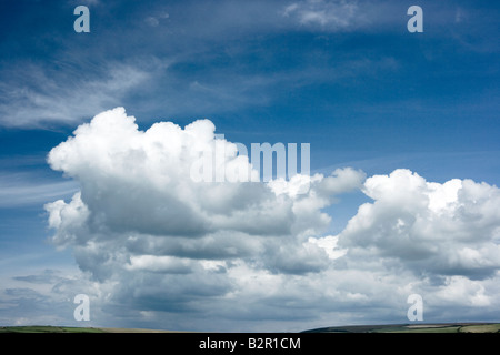 Cumulus Wolken in blauem Himmel über Hügeln Stockfoto