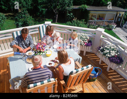 Freunden teilen, Essen, Kaffee und Gespräch am Balkon des schwedischen Einfamilienhaus im Sommer Stockfoto