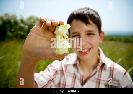 Junge hält Apfel-Kern Stockfoto