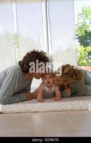 Eltern küssen Babys Wangen, Boden Leben Stockfoto