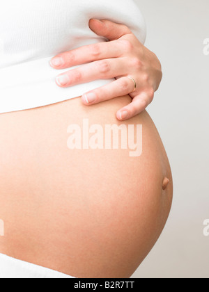 Schwangere Frau ihren Bauch berühren. Stockfoto