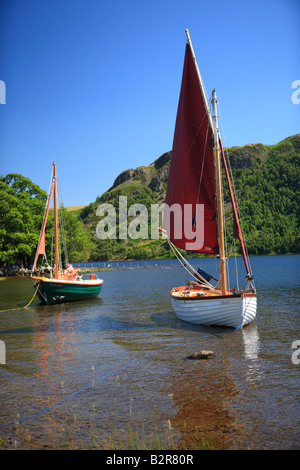 Grüne und weiße Segelboote mit roten Segel festgemacht an in einer Bucht am Ullswater, The Lake District National Park, Cumbria, England, Vereinigtes Königreich Stockfoto