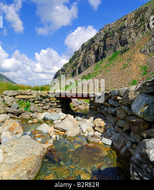 Kleine Holzbrücke überqueren Afon Nant Peris Fluss fließt durch Llanberis Pass in Gwynedd Nord-Wales Stockfoto