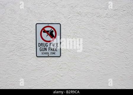 Schusswaffe und Drogenfreie Schulzone Schild mit Schusswaffe und Nadel im roten Kreis und über Handfeuerwaffe schlagen Stockfoto