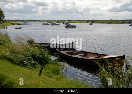 Hölzerne Ruderboote in Athlone am Shannon, mit Hausbooten festgemacht im Hintergrund Stockfoto