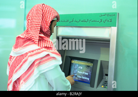 Verwendung von arabischen Geldautomat Kufiya Kopftuch tragen Stockfoto