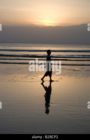 Kuta Bali Indonesien Badebucht Meer Surf Sonnenuntergang Mann Frau zu Fuß Kontemplation Wolke Himmel Wellen kräuseln Reflexion Silhouette Stockfoto