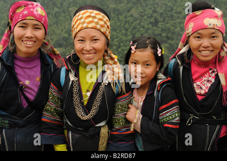 Vier Hmong Girls tragen traditionelle Kostüm lächelnd in die Kamera in den Bergen von Sapa Vietnam Stockfoto