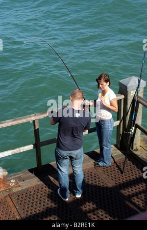 Junges Paar Angeln auf der Mole in Bournemouth England Südengland Stockfoto