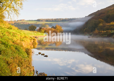 Frühen Morgennebel über River Wye Wye Valley, Monmouthshire, Wales mit Herbst-Farben an den Bäumen Deich Offas. Stockfoto