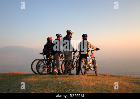 Gruppe von Mountainbikern dauern, den Sonnenuntergang auf dem Gipfel eines Berges. Stockfoto