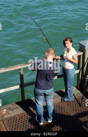 Junges Paar Angeln auf der Mole in Bournemouth England Südengland Stockfoto