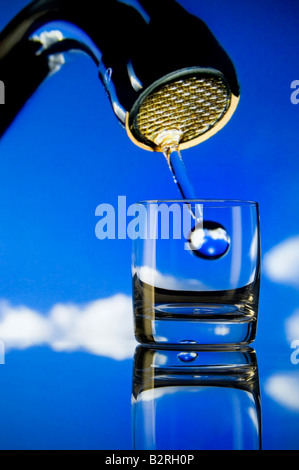 Konzept Erhaltung Fragen große Tröpfchen von Wasser aus großen Hahn fallen in ein kleines Glas Stockfoto