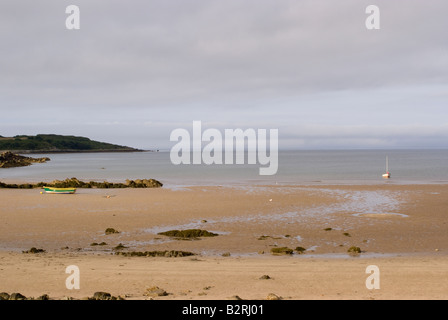 Grüne und gelbe Ruderboot vor Anker am Sandy Beach und Segelboot Carrick Islands of Fleet Wigtown Bay Dumfries und Galloway Stockfoto