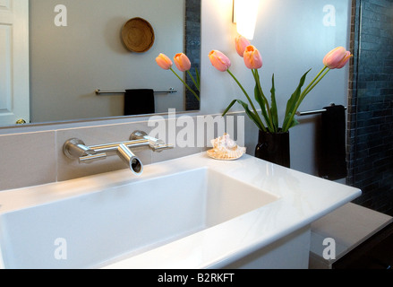 Weiße moderne Waschbecken mit rosa Tulpen Stockfoto