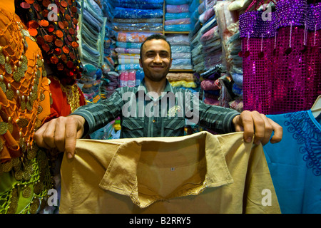 Mann anzeigen Kleidung in seinem Geschäft in der Souk in der Altstadt von Aleppo Syrien Stockfoto