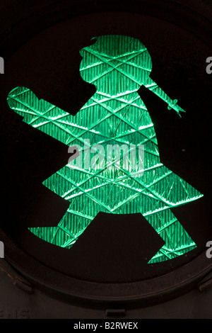 Eine grüne Fußgängerampel in der Form von einem Mädchen mit Zöpfen. Dies ist ein typisch ostdeutschen Licht. Stockfoto