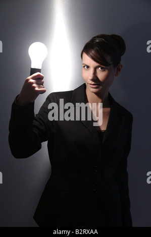 Geschäftsfrau im Alter von 24 mit einer Glühbirne in der hand Stockfoto