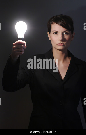 Geschäftsfrau im Alter von 24 mit einer Glühbirne in der hand Stockfoto