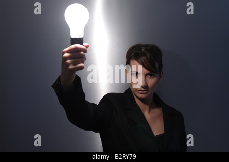 Geschäftsfrau im Alter von 24 mit einer Glühbirne in der hand Stockfoto