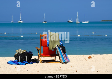 Der Stuhl und die Handtücher sind bereit für einen Tag der Entspannung am sandigen Strand der Karibik Boquerón Bay, Boquerón, Puerto Rico. Stockfoto