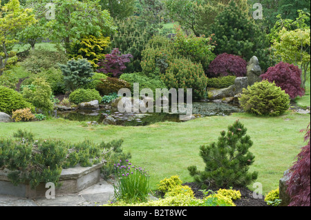 Designed by Bahaa Seedhom mit Terrasse und Teich mit lokalem Sand-Stein, Sträucher, Bäume, North Yorkshire England Mai Steingarten Stockfoto