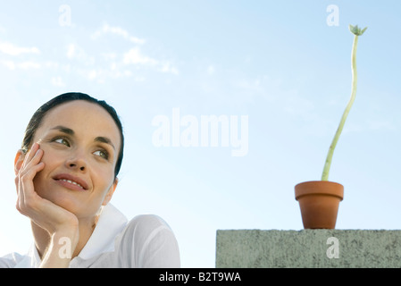Frau mit Pflanze, Lächeln Stockfoto