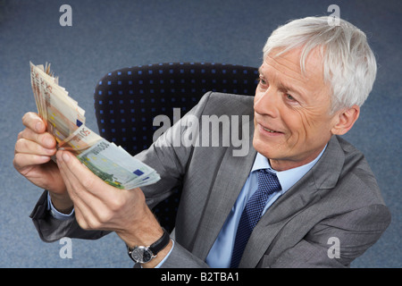 Geschäftsmann mit viel Geld in Händen Stockfoto