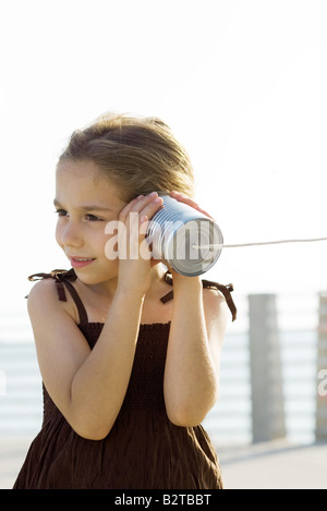 Kleines Mädchen Blechdose Telefon anhören Stockfoto