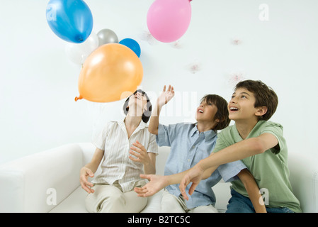 Mutter und zwei Söhne spielen mit Luftballons, nachschlagen Stockfoto