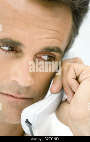Mann mit Festnetz-Telefon, wegsehen, beschnitten Stockfoto