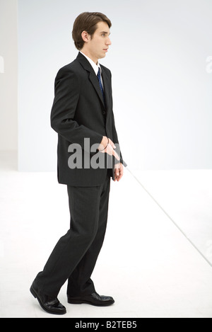 Geschäftsmann zu Fuß mit Blindenstock, Seitenansicht Stockfoto