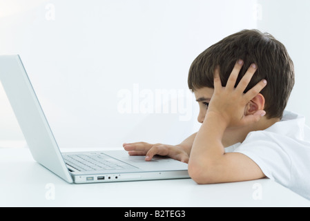 Kleiner Junge mit Laptop-Computer, Kopf, seitliche Ansicht Stockfoto