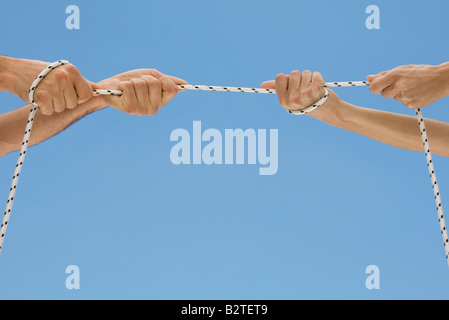 Hände spielen Tauziehen mit Seil Stockfoto