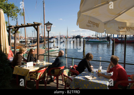 Leute sitzen in Liegestühlen am Hafen, Leute sitzen in Liegestühlen am Sandstrand open-air-Gelände des Restaurant in Övelgönne, Schinken Stockfoto