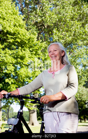 Reife Frau mit Fahrrad Stockfoto