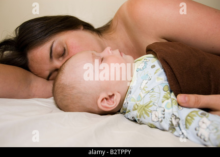 Baby Boy Joshua Kailas Hudson im Alter von 15 Wochen kuscheln, schlafen im Bett der Mutter Deborah Wasser Stockfoto