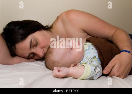 Baby Boy Joshua Kailas Hudson im Alter von 15 Wochen kuscheln, schlafen im Bett der Mutter Deborah Wasser Stockfoto