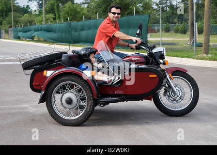 Mann auf dem Motorrad mit Kind im Beiwagen Gainesville Florida URAL YPAN Motorrad aus Russland Stockfoto