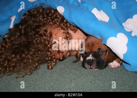 Lockiges Haar und ein Boxer Welpen Stockfoto